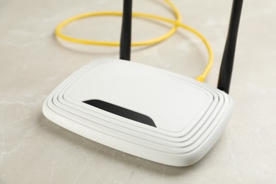 Photo of Modern Wi-Fi router on light grey marble background