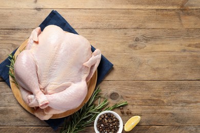 Fresh raw chicken with spices on wooden table, flat lay. Space for text