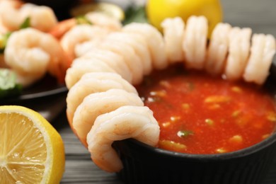 Photo of Tasty shrimp cocktail with sauce on grey wooden table, closeup