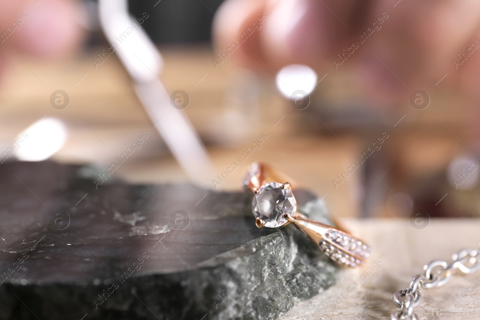 Photo of Diamond ring and blurred jeweler on background