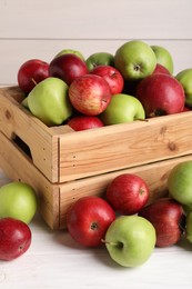 Fresh ripe red and green apples on white wooden table