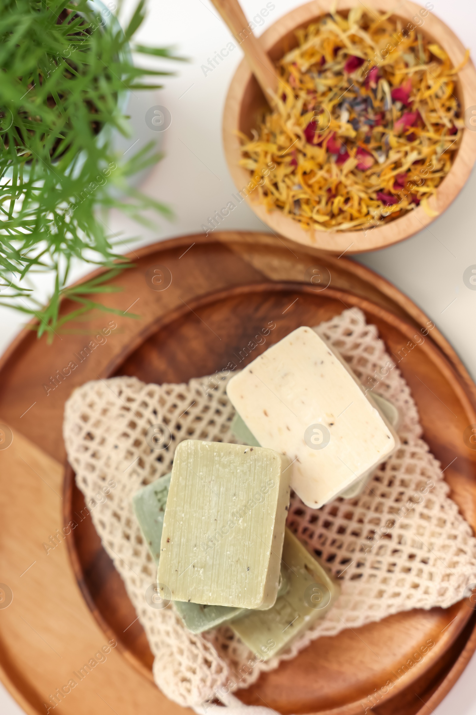 Photo of Soap bars and dry flowers on white table, flat lay. Spa time