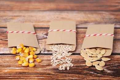 Photo of Many different vegetable seeds on wooden table, closeup