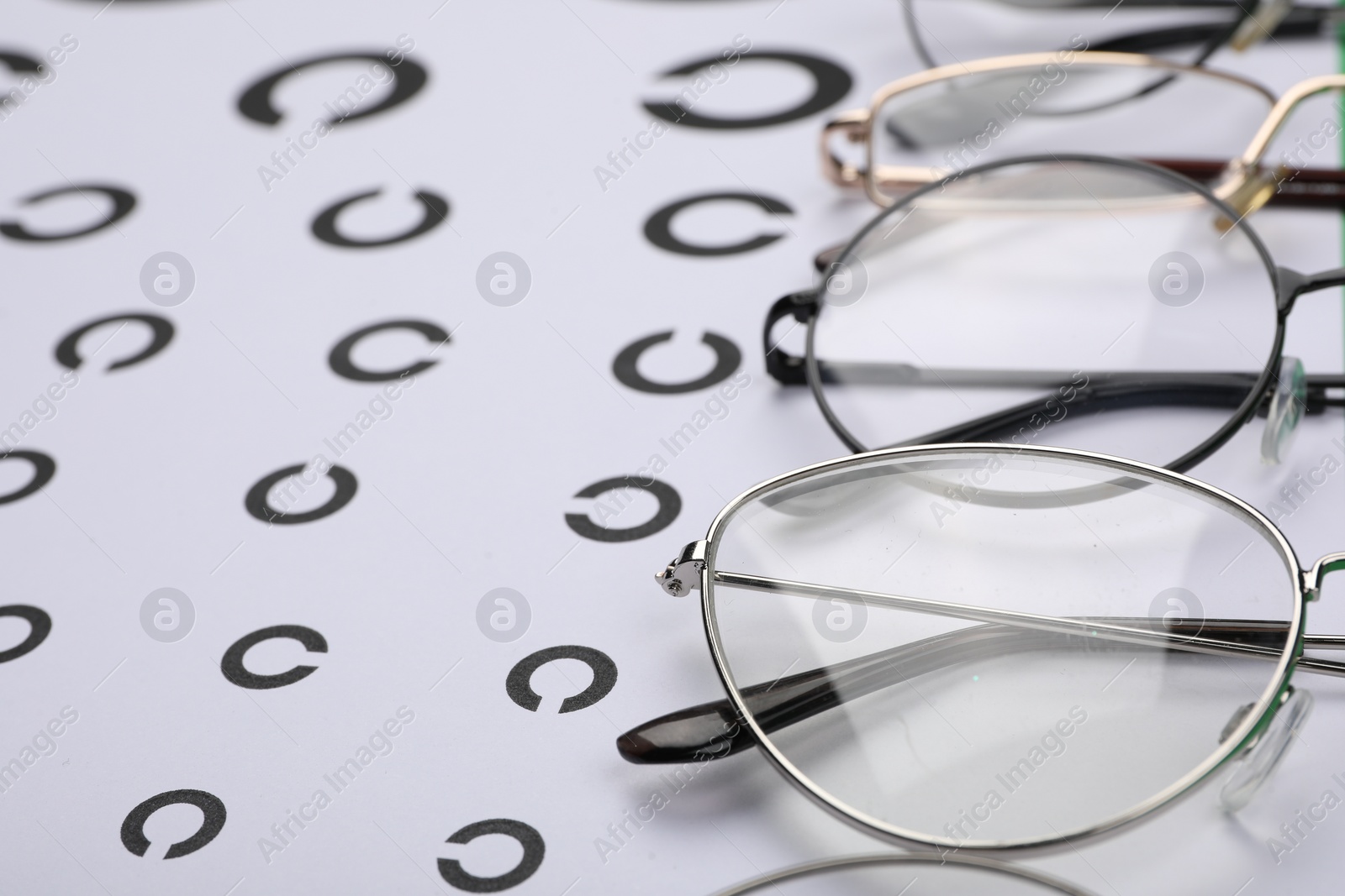 Photo of Vision test chart and different glasses, closeup