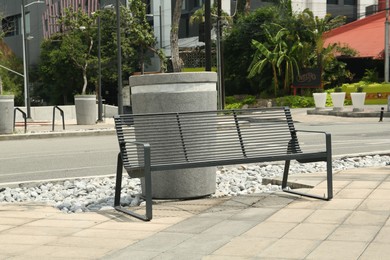 Stylish metal bench in park on sunny day