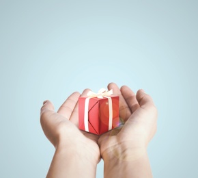 Image of Boxing day. Woman with gift on light background, closeup 