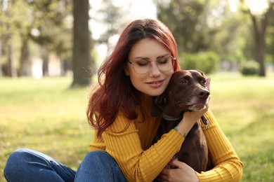 Woman with her cute German Shorthaired Pointer dog in park on spring day