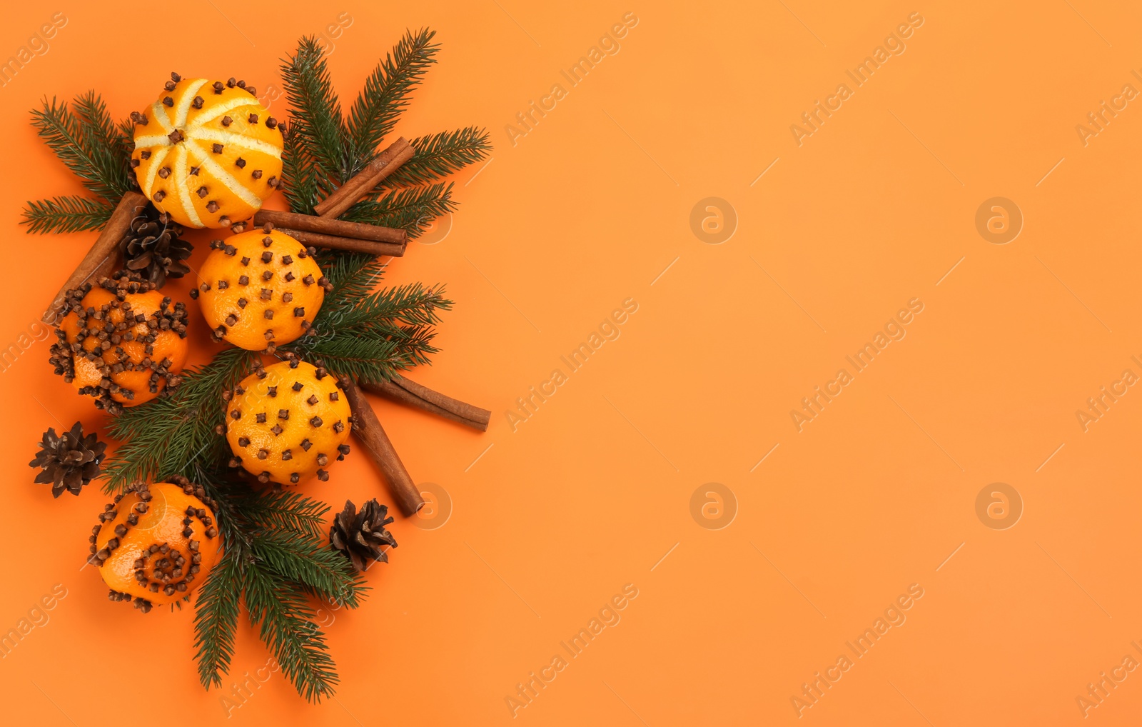 Photo of Flat lay composition with pomander balls made of fresh tangerines on orange background. Space for text