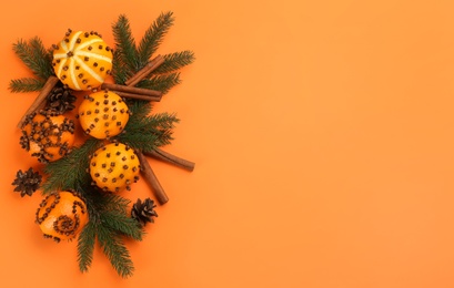 Photo of Flat lay composition with pomander balls made of fresh tangerines on orange background. Space for text