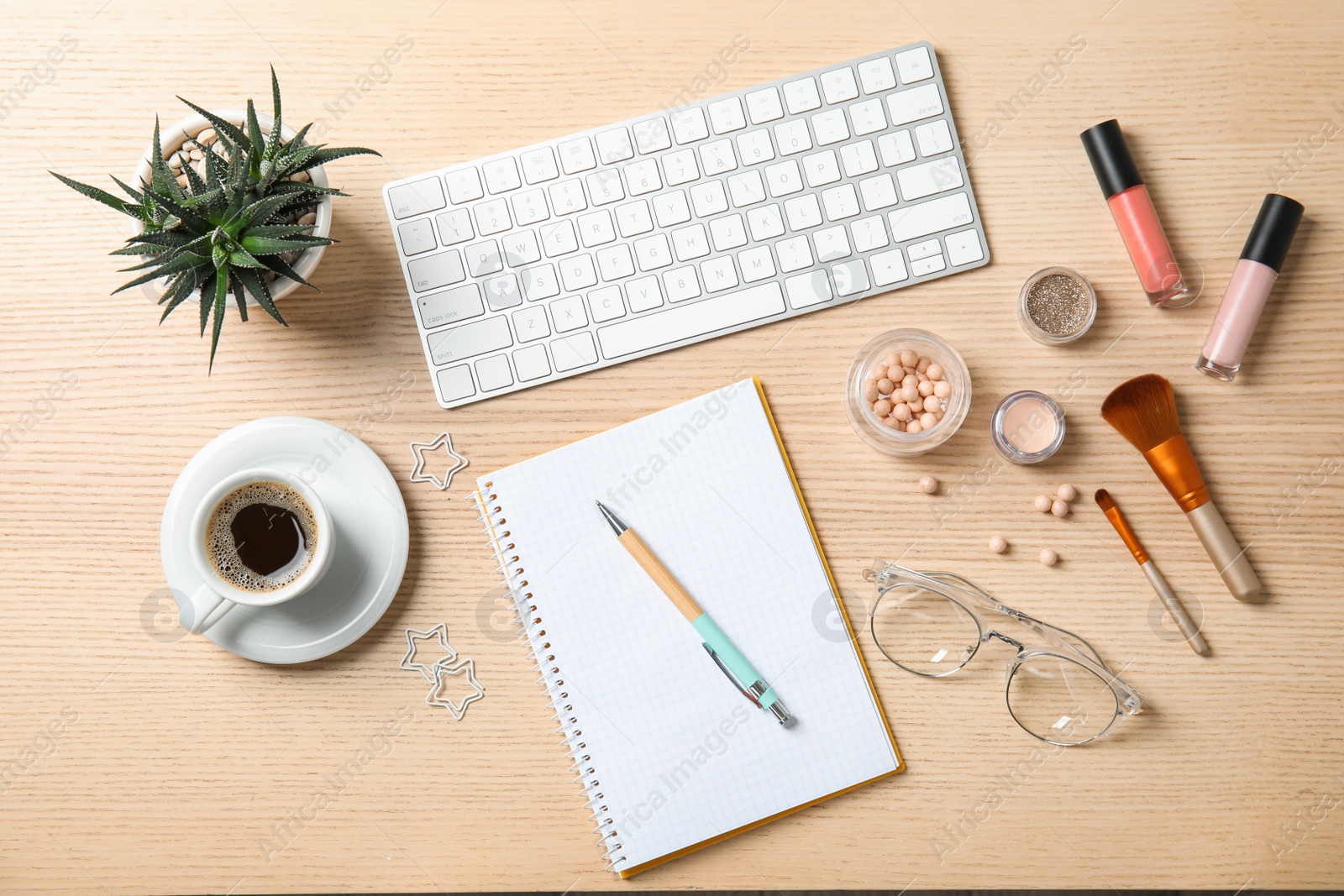 Photo of Flat lay composition with computer keyboard, cosmetics and notebook on wooden table. Blogger's workplace