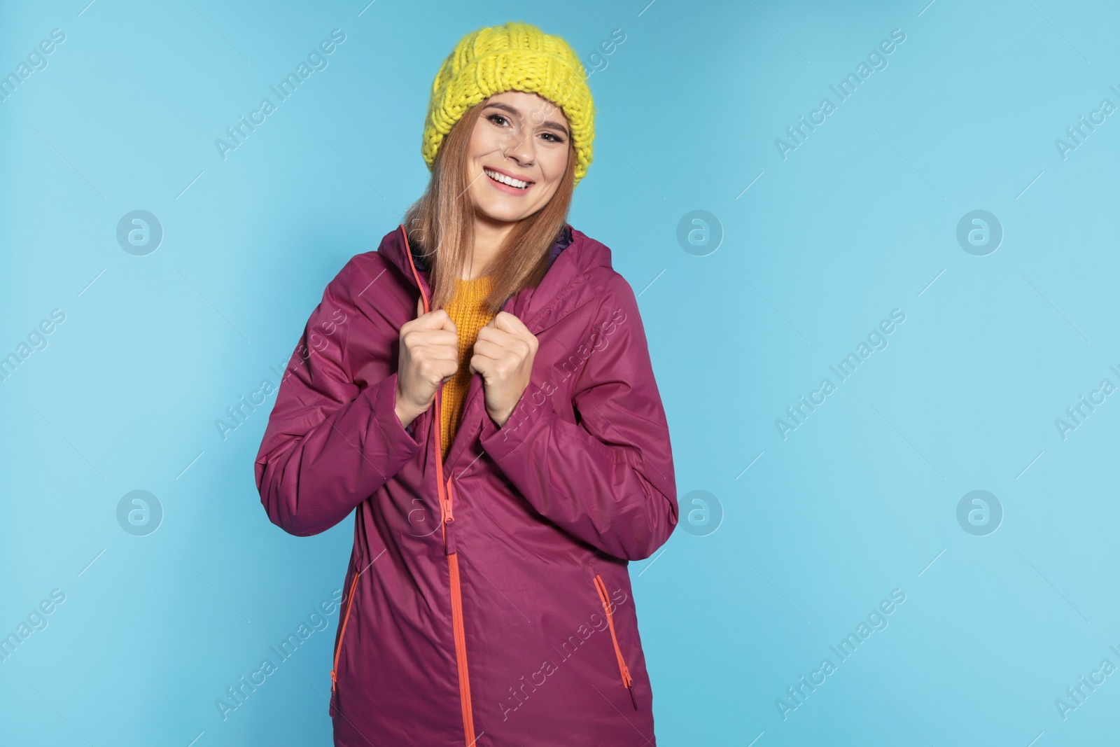 Photo of Young woman wearing warm clothes on color background. Ready for winter vacation
