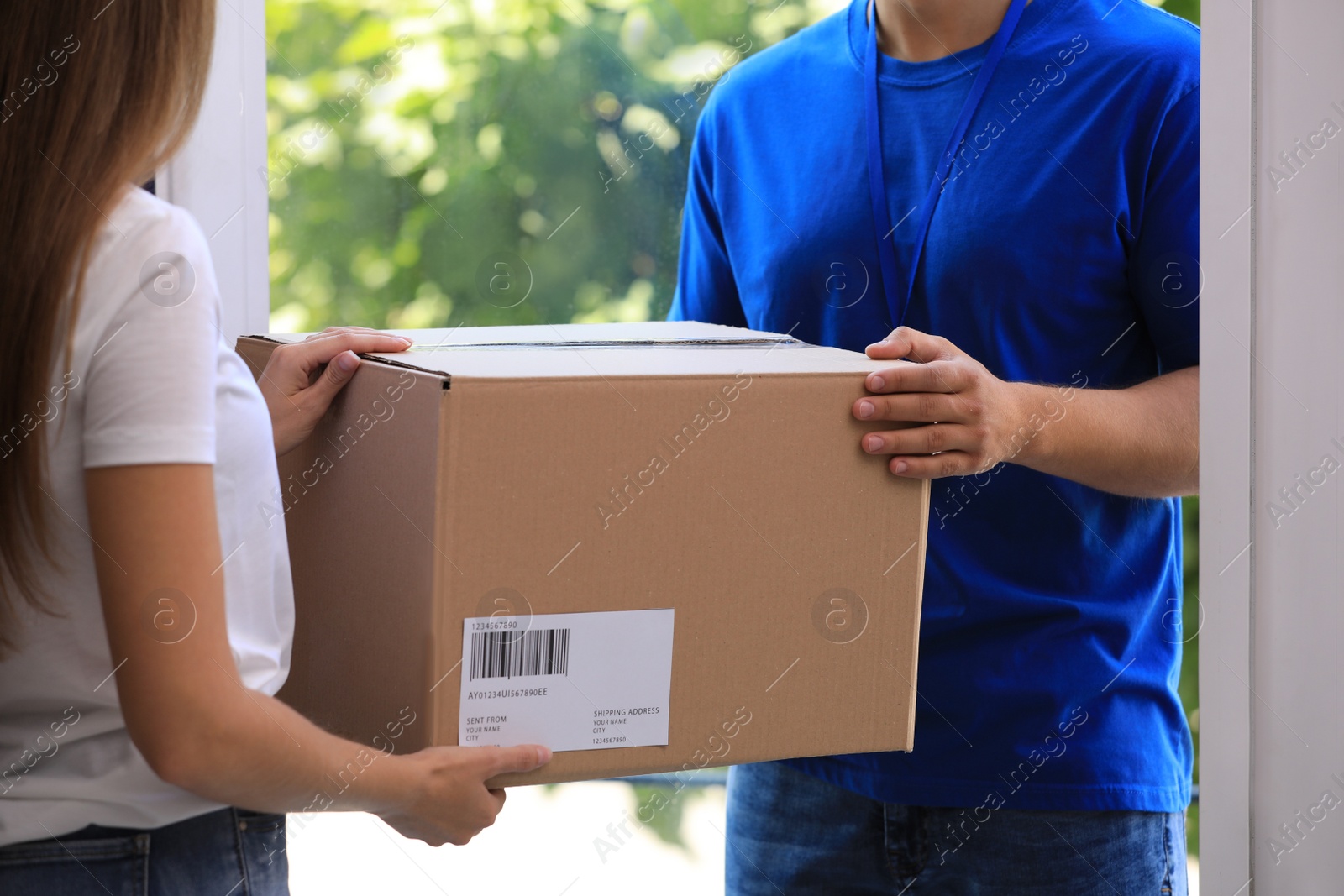Photo of Woman receiving parcel from courier on doorstep, closeup