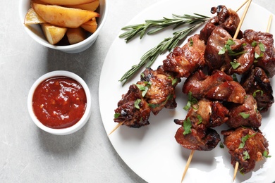 Photo of Plate of delicious meat served on gray table, top view