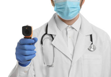 Photo of Doctor in latex gloves holding non contact infrared thermometer on white background, closeup. Measuring temperature