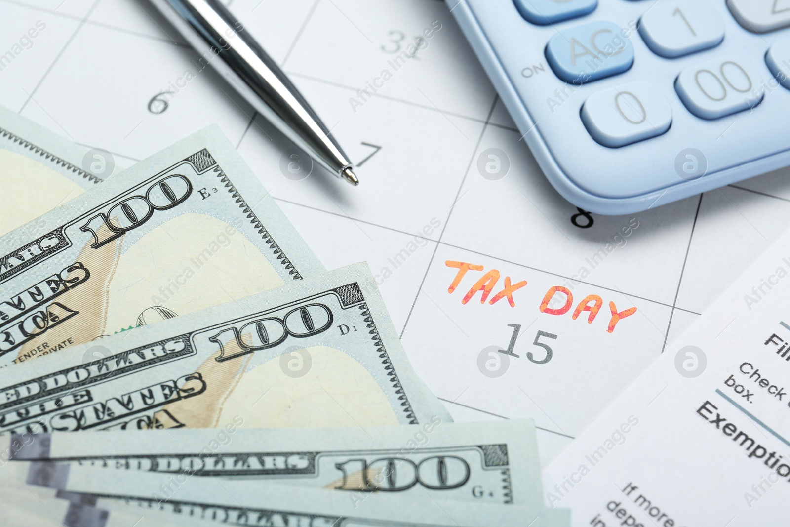 Photo of Tax day. Document, dollar banknotes, calculator and pen on calendar with date reminder