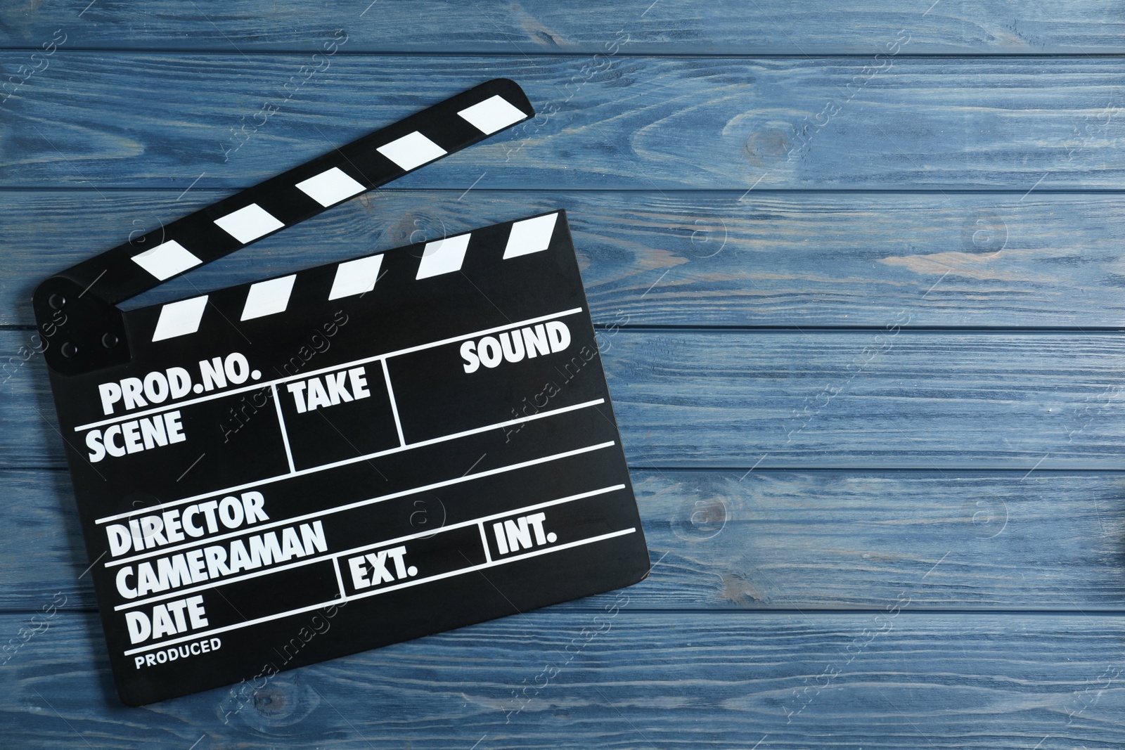 Photo of Clapper board on blue wooden background, top view with space for text. Cinema production