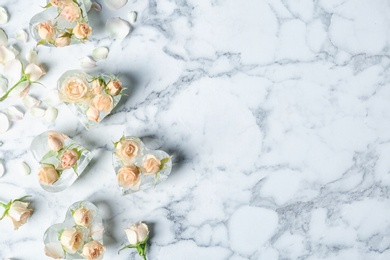 Heart shaped ice cubes with roses on marble background, flat lay composition. Space for text