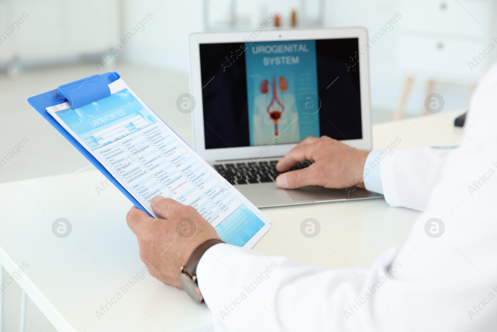 Photo of Mature urologist working at table in hospital
