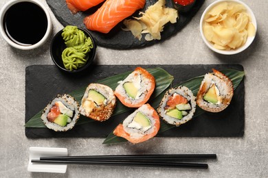 Photo of Different tasty sushi rolls on light grey table, flat lay