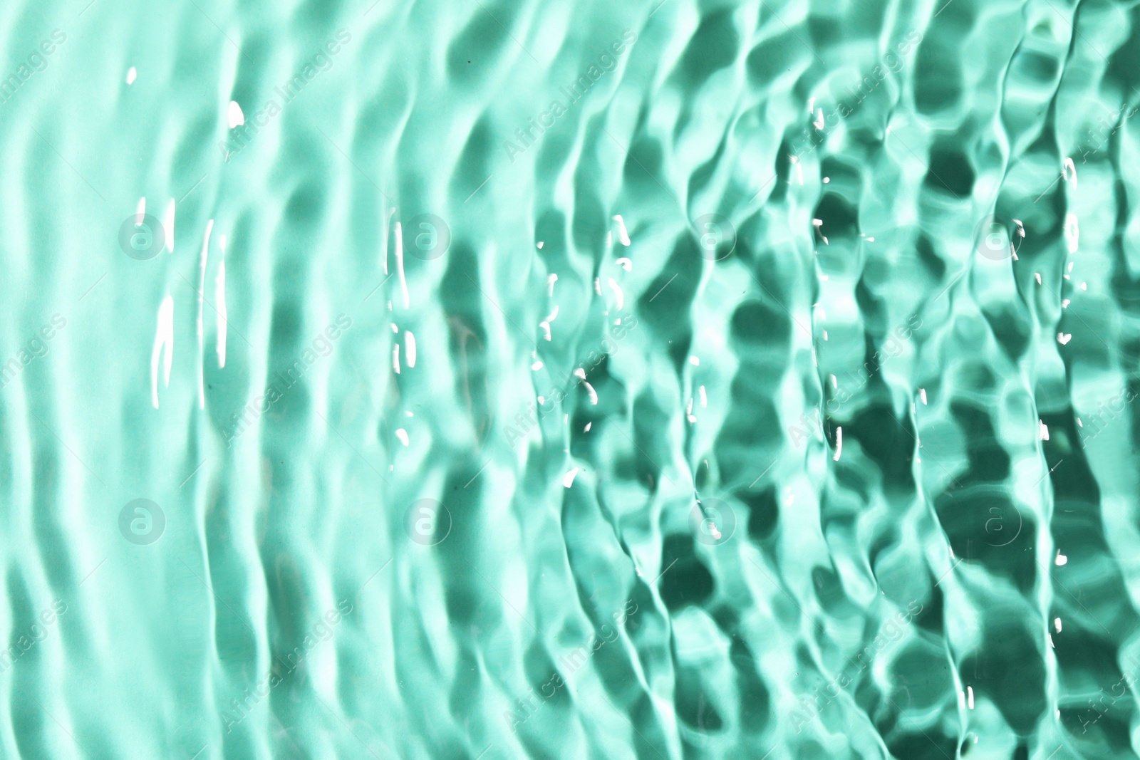 Photo of Closeup view of water with rippled surface on light blue background