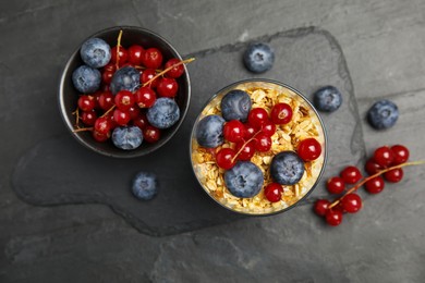 Photo of Delicious yogurt parfait with fresh berries on black table, flat lay