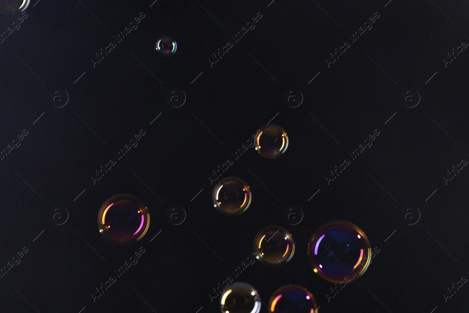 Photo of Beautiful transparent soap bubbles on dark background