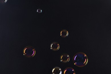 Photo of Beautiful transparent soap bubbles on dark background