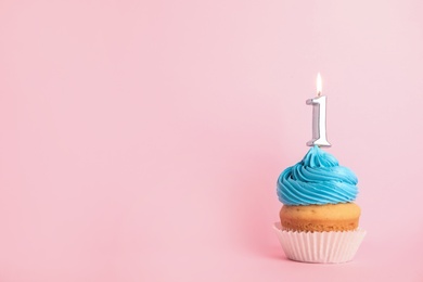Photo of Birthday cupcake with number one candle on pink background, space for text