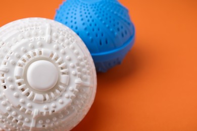 Laundry dryer balls on orange background, closeup. Space for text