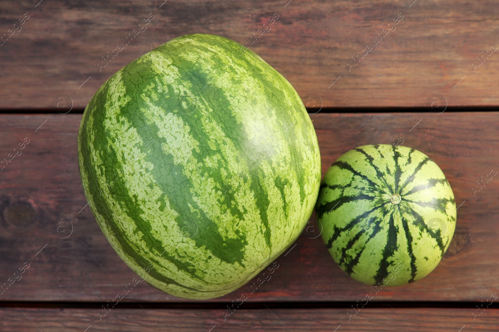 Photo of Different delicious ripe watermelons on wooden table, top view