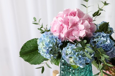 Photo of Beautiful hortensia flowers in vase indoors, closeup