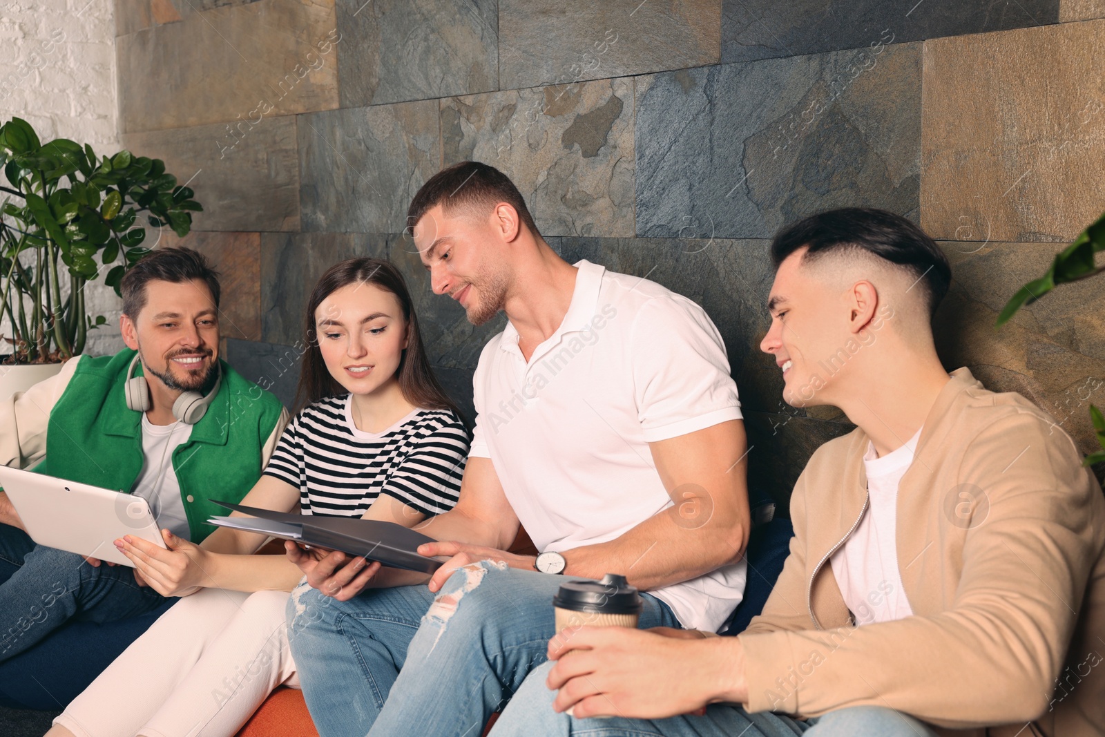 Photo of Office employees enjoying break together in recreation room at work