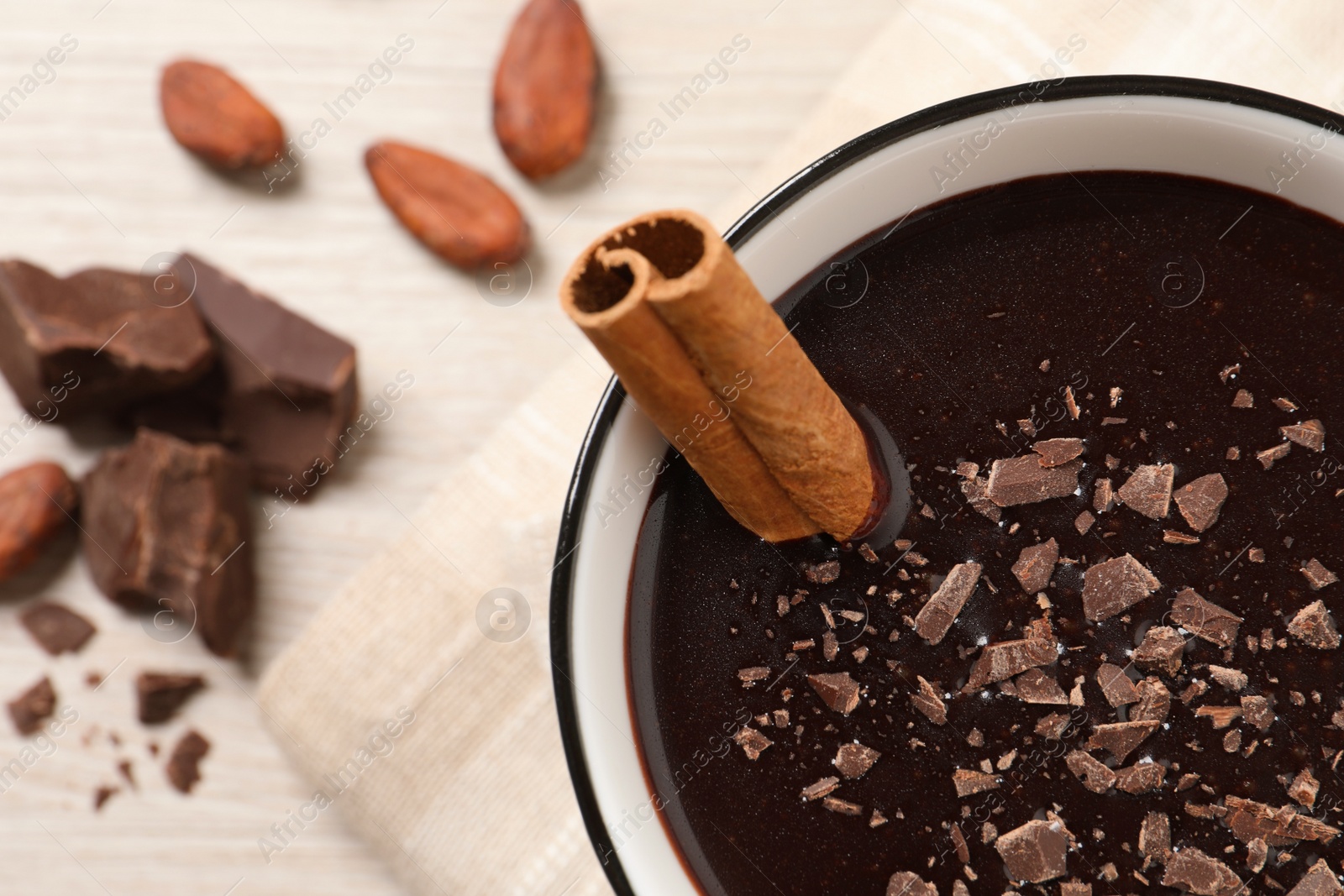 Photo of Yummy hot chocolate with cinnamon in cup on white table, closeup