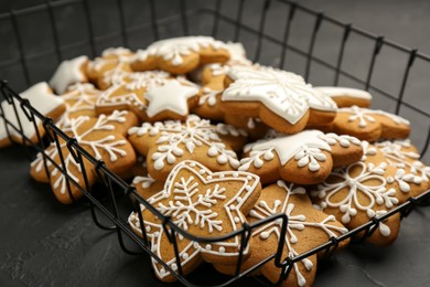 Photo of Tasty Christmas cookies with icing on black table, closeup