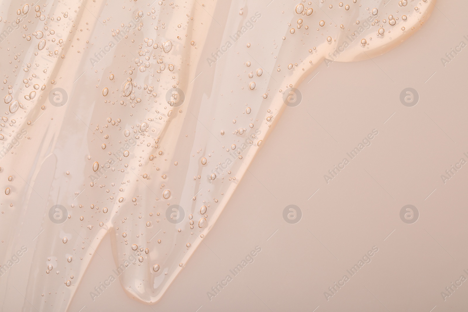 Photo of Pure transparent cosmetic gel on beige background, top view