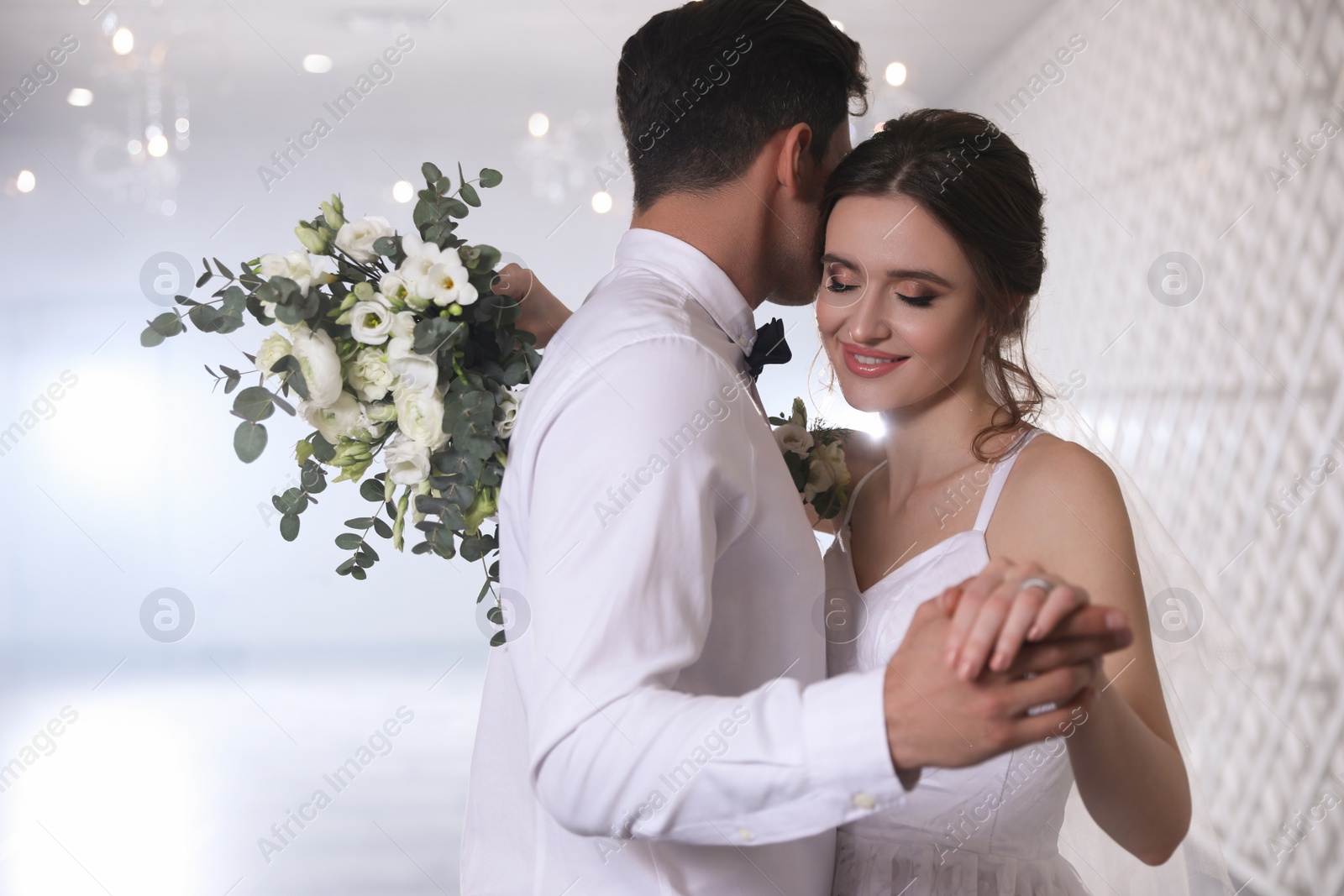 Photo of Happy newlywed couple dancing together in festive hall