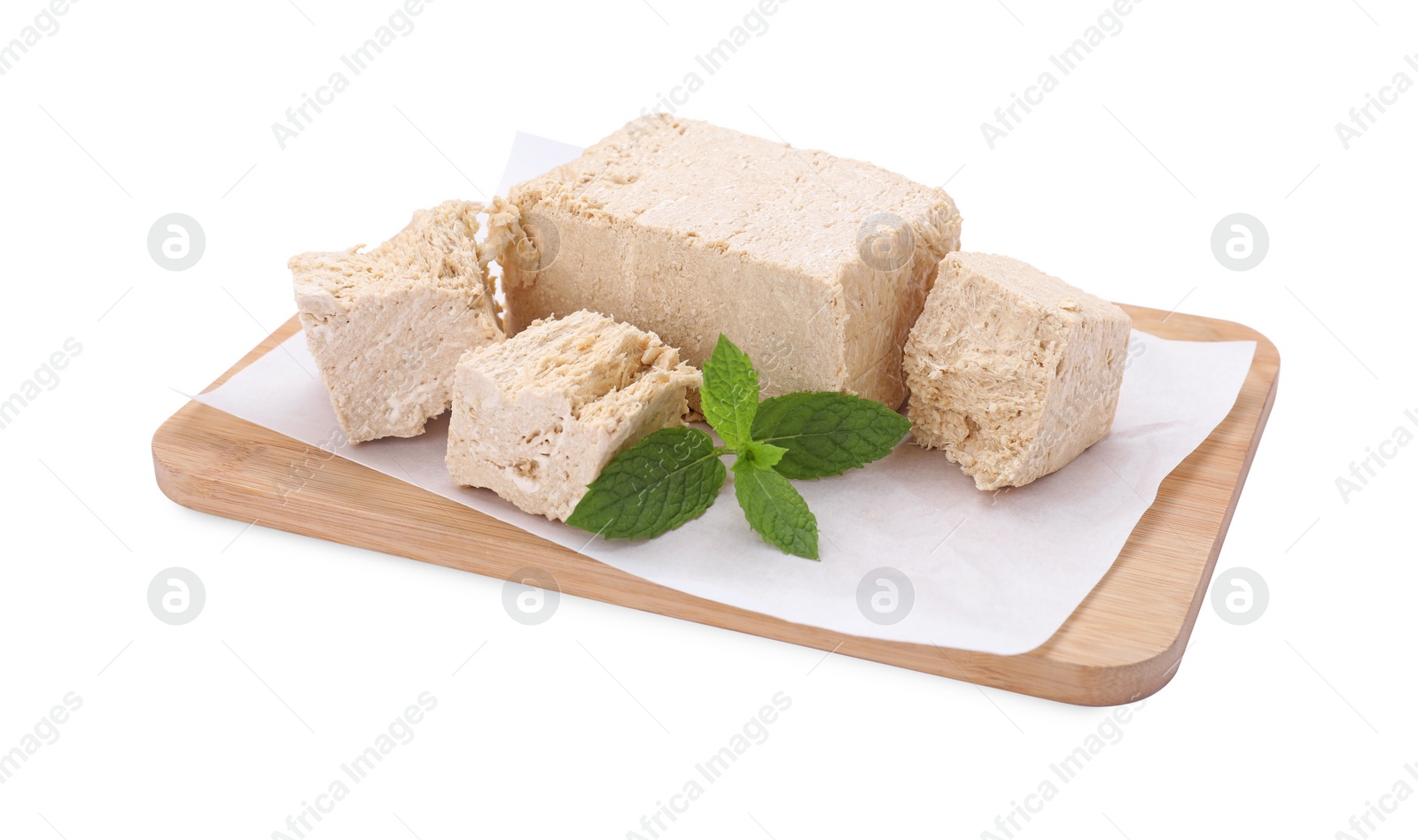 Photo of Board with pieces of tasty halva and mint isolated on white