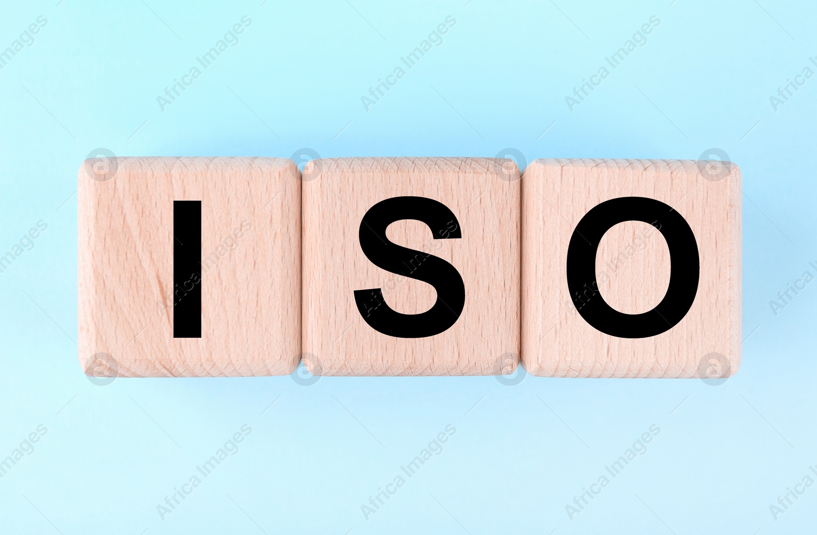 Photo of International Organization for Standardization. Wooden cubes with abbreviation ISO on light blue background, top view