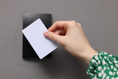 Photo of Woman opening magnetic door lock with key card, closeup. Home security