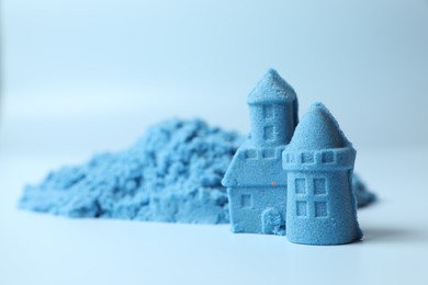 Photo of Castle figures made of kinetic sand on light blue background, closeup. Space for text