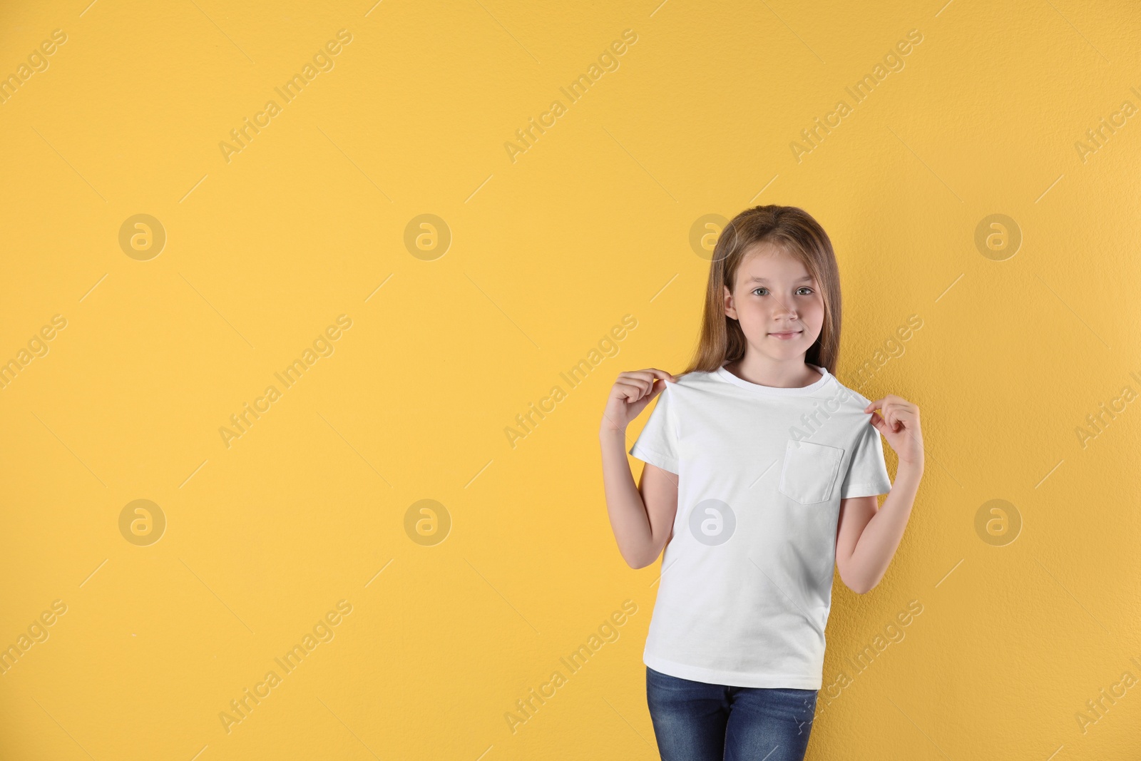 Photo of Little girl in t-shirt on color background. Mockup for design