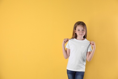 Photo of Little girl in t-shirt on color background. Mockup for design