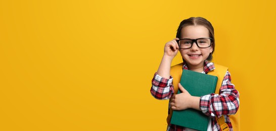 Image of First time at school. Cute little child wearing glasses on yellow background, space for text. Banner design