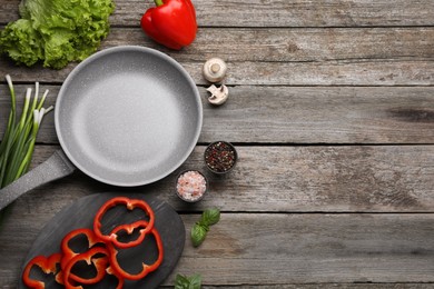 Photo of Flat lay composition with frying pan and fresh products on wooden table, space for text