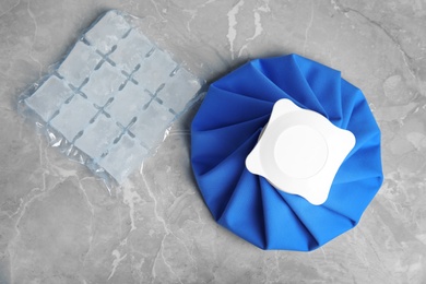 Composition with ice pack on marble table, flat lay