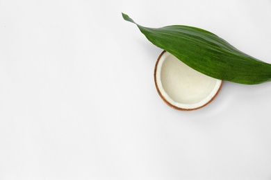 Photo of Half of fresh coconut and palm leaf on white background, top view