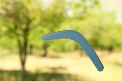 Throwing of boomerang outdoors on sunny day. Bokeh effect