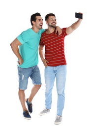 Photo of Happy young men taking selfie on white background