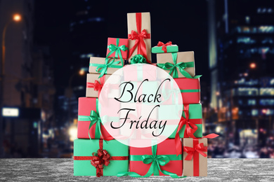 Image of Black Friday. Many gift boxes and blurred cityscape on background