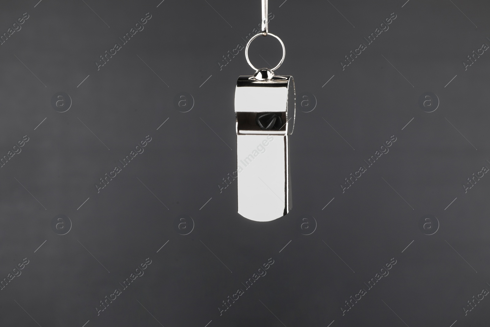 Photo of Referee whistle against empty black chalkboard, closeup